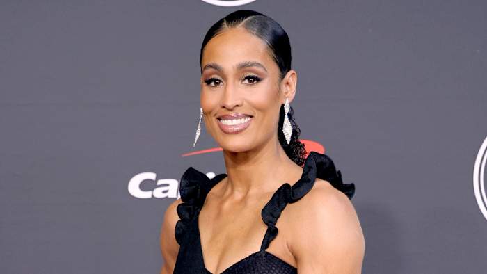 Skylar Diggins-Smith smiles at the camera, wearing a black gown with ruffled straps and her hair in an up-do.